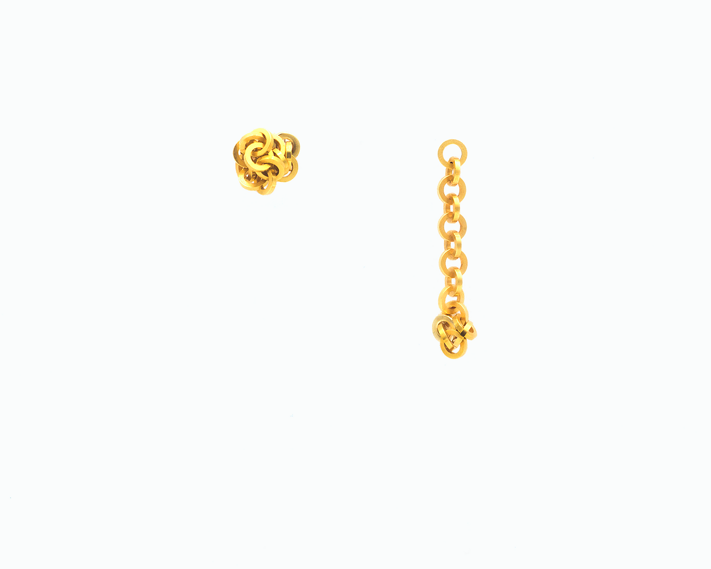 Zu sehen ist hier ein variabel tragbares Ohrschmuck-Paar.  Beide Stecker sind frontal gezeigt. Beim rechten Ohrstecker hängt das Kettenstück aus ineinander eingehängten Kreisringelementen mit Vierkantprofil nach unten, wobei ein paar Kettenelemente an den unten sitzenden Magneten angedockt sind. Der linke Ohrstecker wird als kurzer Ohrstecker in Form eines Knäuels gezeigt. Der Ohrschmuck ist goldfarben. Er ist aus Edelstahl, Feingold plattiert.
