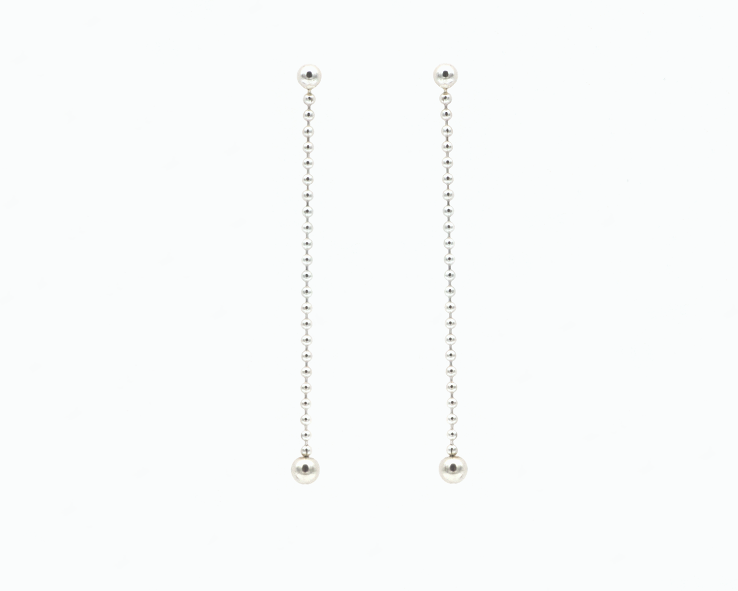 Zu sehen ist hier ein hängendes Ohrschmuck-Paar. Es sind zwei mit der Vorderseite nach vorne zeigende und nach unten hängende Kugelkettenstücke, an deren Abschluss unten jeweils eine größere Magnetkugel sitzt. Der Ohrschmuck ist silberfarben. Er ist aus Edelstahl, Silber plattiert.