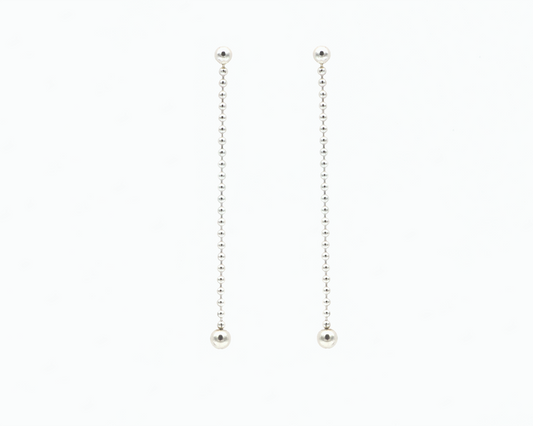 Zu sehen ist hier ein hängendes Ohrschmuck-Paar. Es sind zwei mit der Vorderseite nach vorne zeigende und nach unten hängende Kugelkettenstücke, an deren Abschluss unten jeweils eine größere Magnetkugel sitzt. Der Ohrschmuck ist silberfarben. Er ist aus Edelstahl, Silber plattiert.